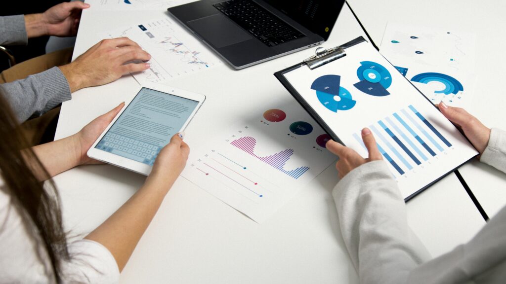 A team analyzing financial charts and digital reports during a business meeting.